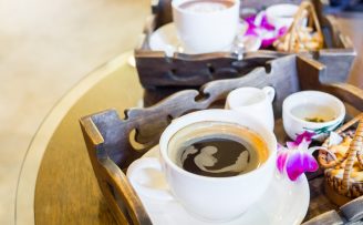 Hot black coffee set with cookies and orchids decorated on the table